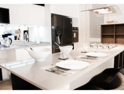 a kitchen with a counter with white plates and utensils at ANDARES, MAGNIFICO DEPTO DE LUJO Piso 19 LOBBY 33 in Guadalajara