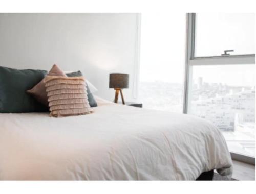 a bedroom with a white bed with a window at ANDARES, MAGNIFICO DEPTO DE LUJO Piso 19 LOBBY 33 in Guadalajara