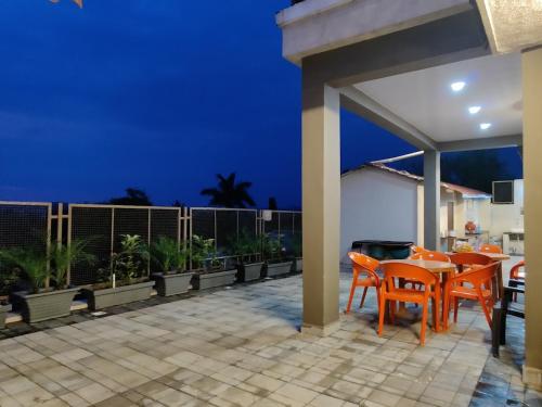 a patio with orange chairs and tables at night at Raj Heritage in Murbād