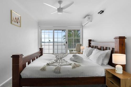 a bedroom with a large bed with a window at Waterfront Escape Kayaks and Home in Gorokan