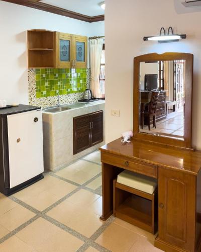 a kitchen with a wooden desk and a mirror at Ongsantiphap villa resort in Ban Klang