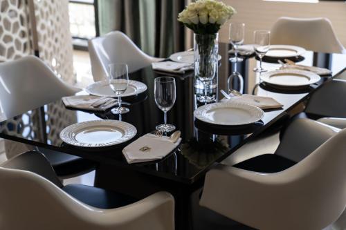 a black table with white plates and glasses and chairs at Fairmont Riyadh in Riyadh