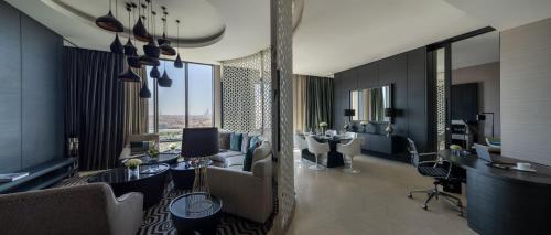 a hotel room with a lobby with tables and chairs at Fairmont Riyadh in Riyadh