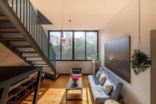 a living room with a couch and a staircase at Deluxe Apartment W Private Terrace Reforma Av in Mexico City