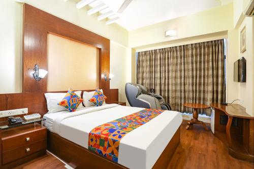 een hotelkamer met een bed, een bureau en een bureau bij FabHotel Shubhangan in Mumbai
