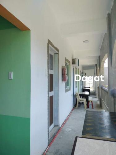 a hallway with a door and a table in a room at Glenmark's Homestay New Oceanview Rooms in Pagudpud