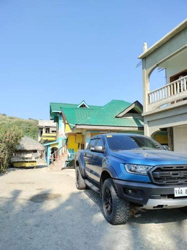 a blue truck parked in front of a house at Glenmark's Homestay New Oceanview Rooms in Pagudpud
