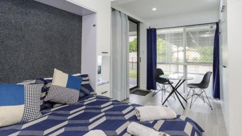 a bedroom with a bed and a table and chairs at Bella Cove in Bellara