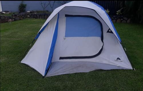 una tenda blu e bianca seduta sull'erba di Robbins Estate a Wailuku