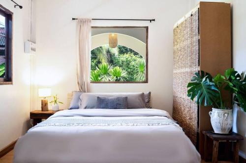 una camera da letto con un letto grande e una finestra di Baan Yucca - House In Lamai a Nathon Bay