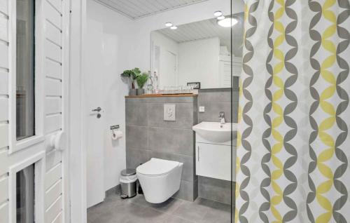 a bathroom with a toilet and a sink at Charming Cottage Close To The Beach in Vester Sømarken