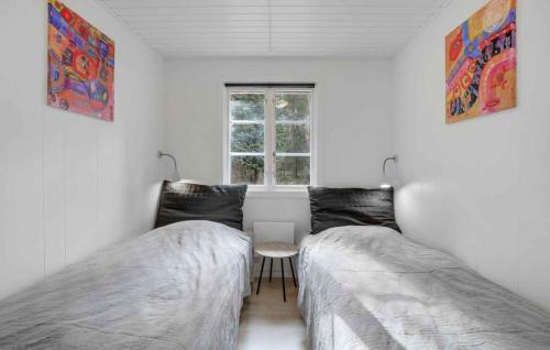 2 camas en una habitación blanca con ventana en Charming Cottage Close To The Beach en Vester Sømarken