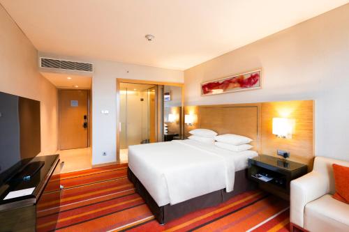 a hotel room with a bed and a couch at Courtyard by Marriott Pune Hinjewadi in Pune