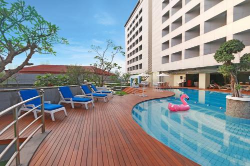 a swimming pool with chairs and a pool toy in a building at Hotel Bidakara Jakarta in Jakarta