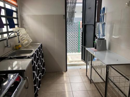 a small kitchen with a sink and a counter at Al Ghazali Homestay in Seri Iskandar