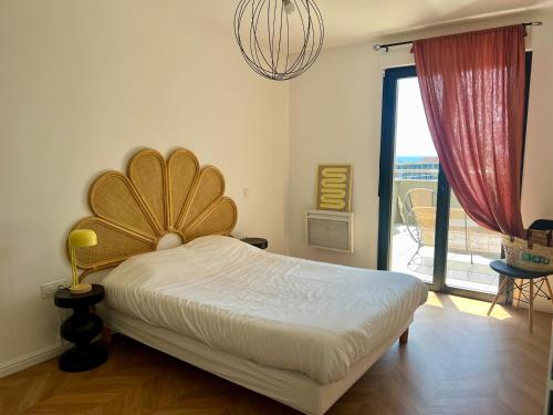 a bedroom with a bed and a large window at T2 Ajaccio vue mer in Ajaccio