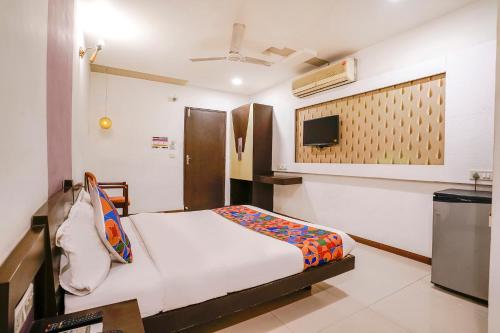 Gorwa的住宿－FabHotel Prime Riddhi Siddhi，卧室配有一张床,墙上配有电视。