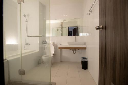 a bathroom with a shower and a toilet and a sink at Room 36 service apartment in Bangkok