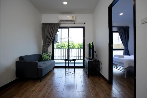 a living room with a couch and a bed and a mirror at Room 36 service apartment in Bangkok