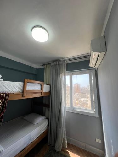 Downtown Sea View Suites في الإسكندرية: غرفة نوم بسريرين بطابقين ونافذة