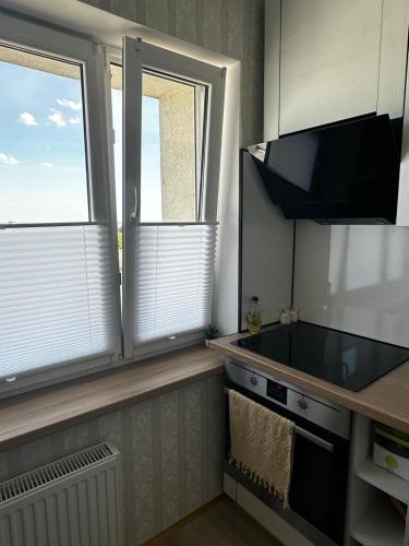a kitchen with two large windows and a sink at Liela Studio Liela Street in Liepāja