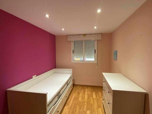 - une chambre avec 2 lits et un mur violet dans l'établissement Puerto de Sagunt America 39, à Puerto de Sagunto