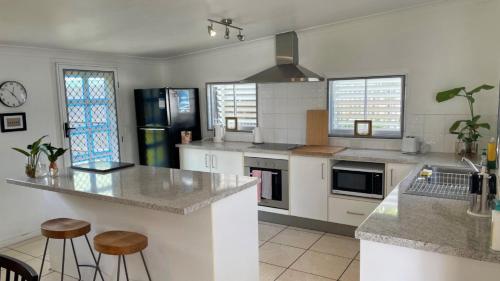 a kitchen with a counter and stools in it at Close to Water, Restaurants and Clubs, Toorbul St, Bongaree in Bongaree