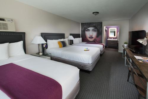 a hotel room with two beds and a tv at Hotel Iris - Mission Valley-San Diego Zoo-SeaWorld in San Diego