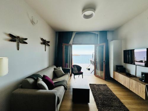 a living room with a couch and a flat screen tv at Apartments Lungo Mare in Sveti Stefan