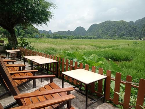 a row of tables and chairs in front of a field at Tam Coc Village Bungalow in Ninh Binh