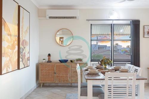 a dining room with a table and chairs and a mirror at ZEN FORESHORE: 3-BR Nightcliff Foreshore-Front Apt in Nightcliff