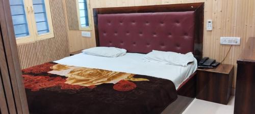 a bedroom with a large bed with a red headboard at Hotel Host near Taj in Agra