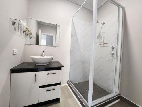 a white bathroom with a shower and a sink at Unit 51 Seafront Estate in Jurien Bay
