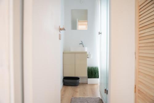 a white bathroom with a sink and a mirror at Pineplace trio KOPA in Žaugėdai