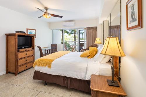 a bedroom with a large bed and a television at Waikiki Shore Beachfront in Honolulu