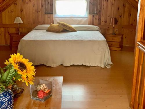 a bedroom with a bed and a vase of sunflowers at Apartamentos la Jayma del Arte in Asque