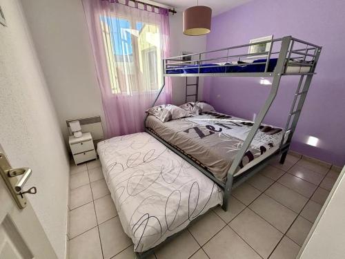 a bedroom with a bunk bed and a purple wall at Villa charmante à Saint-Georges-de-Didonne avec piscine privée. in Saint-Georges-de-Didonne