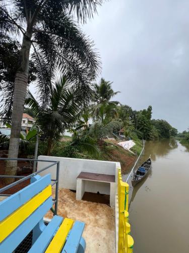 a bench sitting on the side of a river at Alappattu meadows in Kottayam