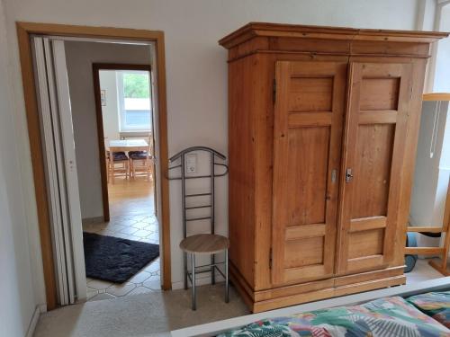 a bedroom with a wooden wardrobe and a ladder next to a door at Ferienwohnung Gulde N tal in Waldhilbersheim