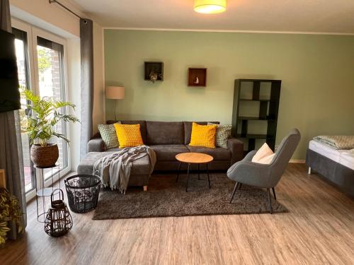uma sala de estar com um sofá e uma mesa em Neues Apartment Nordisch bei Nature by Fewo & Zimmer Bruns em Emden