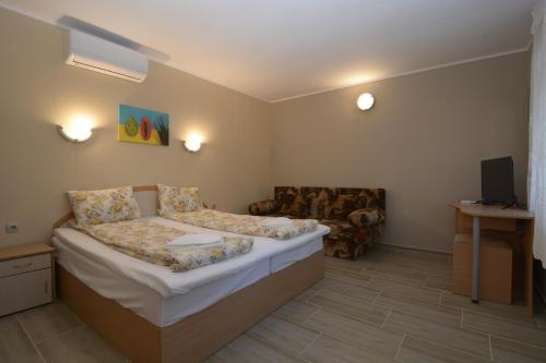mały pokój z łóżkiem i kanapą w obiekcie Atlantic Complex Ravda w Rawdzie
