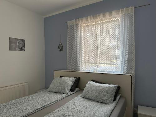a bedroom with two beds and a window at Cozy Apartment next Outlet Center & Airport with Pool & Garden in Parndorf