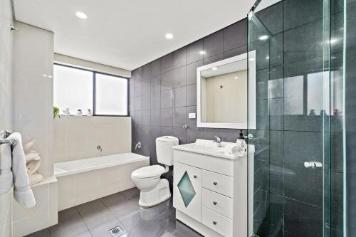 a bathroom with a sink toilet and a shower at Spacious Modern Apartment with Breathtaking Views in Terrigal