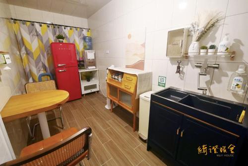cocina con fregadero y nevera roja en 寮寓x綺澄 包棟宅, en Xiaoliuqiu