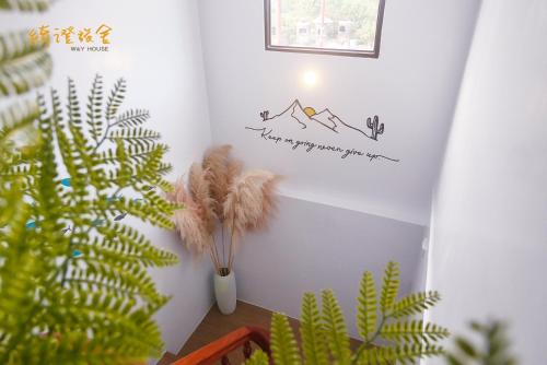 una habitación con una planta y una pared con una pegatina de montaña en 寮寓x綺澄 包棟宅, en Xiaoliuqiu