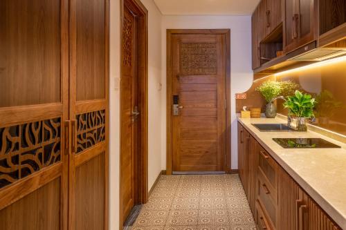 a kitchen with wooden cabinets and a wooden door at Bonny Boutique Hotel Da Nang in Da Nang