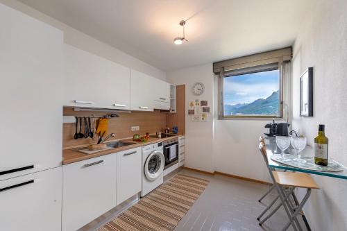 a kitchen with white cabinets and a table with wine glasses at BoReal Apartments in Paradiso