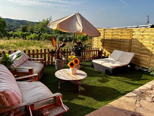a patio with a table and chairs and an umbrella at Apartamentos la Jayma del Arte in Asque