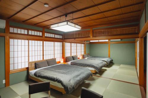 three beds in a room with windows at 珀 Haku in Miyazu