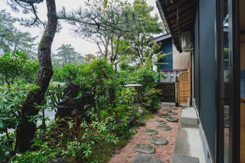 una pasarela al lado de una casa con un árbol en 珀 Haku, en Miyazu